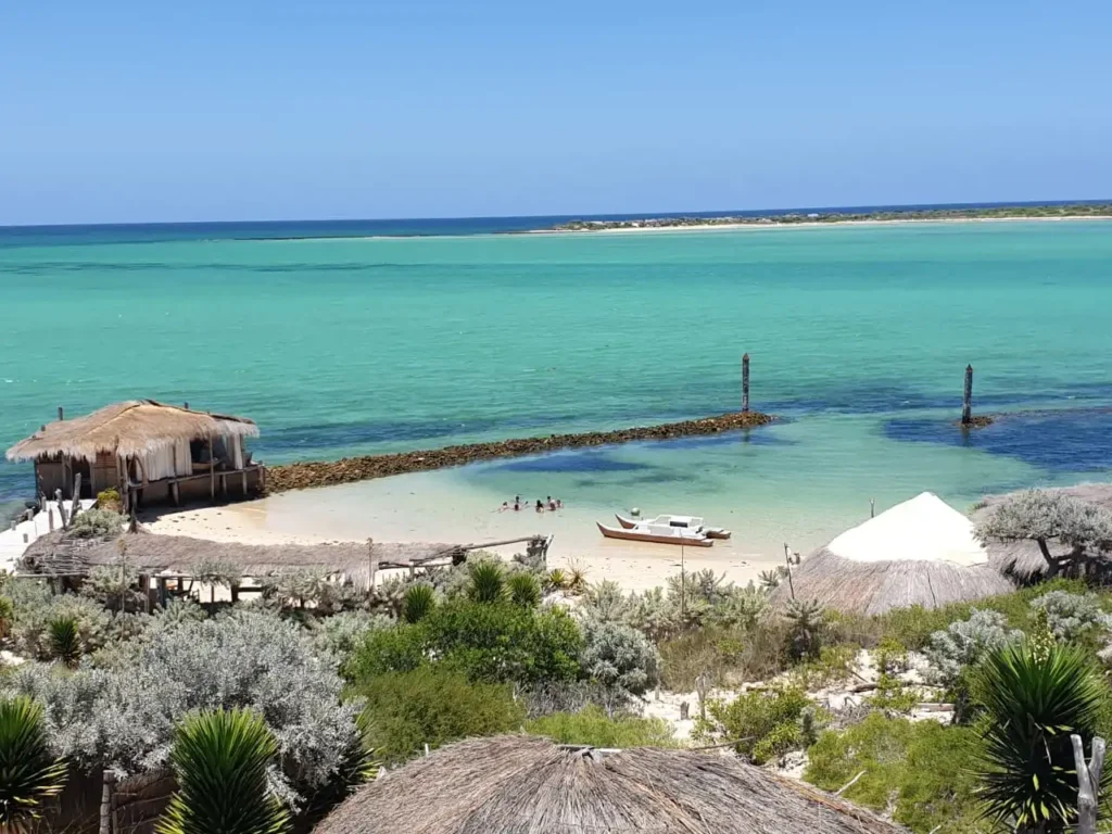 Madagascar best beaches, Scenic southwest Madagascar beach, Tropical Anakao Beach, Madagascar, Stunning Indian Ocean coastline, Remote idyllic beach getaway, Untouched natural beauty of Madagascar, Panoramic views of Anakao, Tranquil turquoise waters, Soft white sand beaches, Lush green coastal vegetation, Perfect for swimming, sunbathing, and relaxation